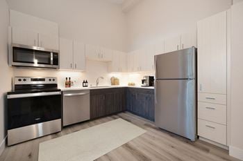 A modern kitchen with stainless steel appliances and white cabinets